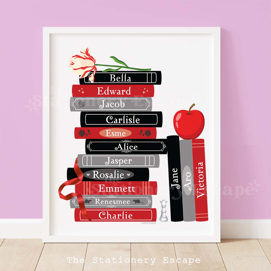 Framed book stack art print featuring character names including Bella and Edward from the famous sparkly vampire book series. The book stack is topped by a red-tinged white flower, an apple, and a red ribbon.