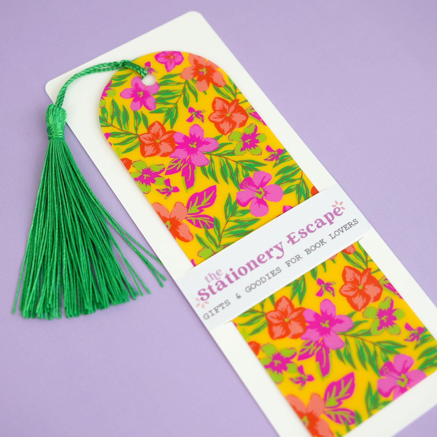 Floral bookmark with green tassel on a purple background