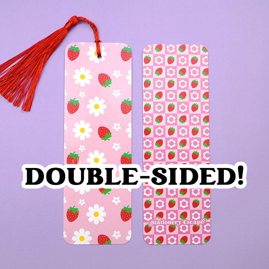 Two double-sided bookmarks with strawberry and daisy flower patterns on a purple background.
