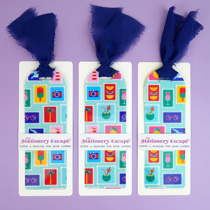 Three bookmarks with colorful designs and blue ribbons on a purple background.