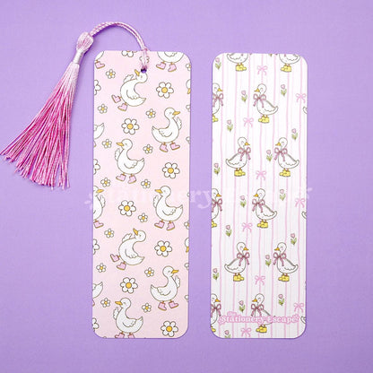 Two bookmarks with pink goose and flower patterns on a purple background