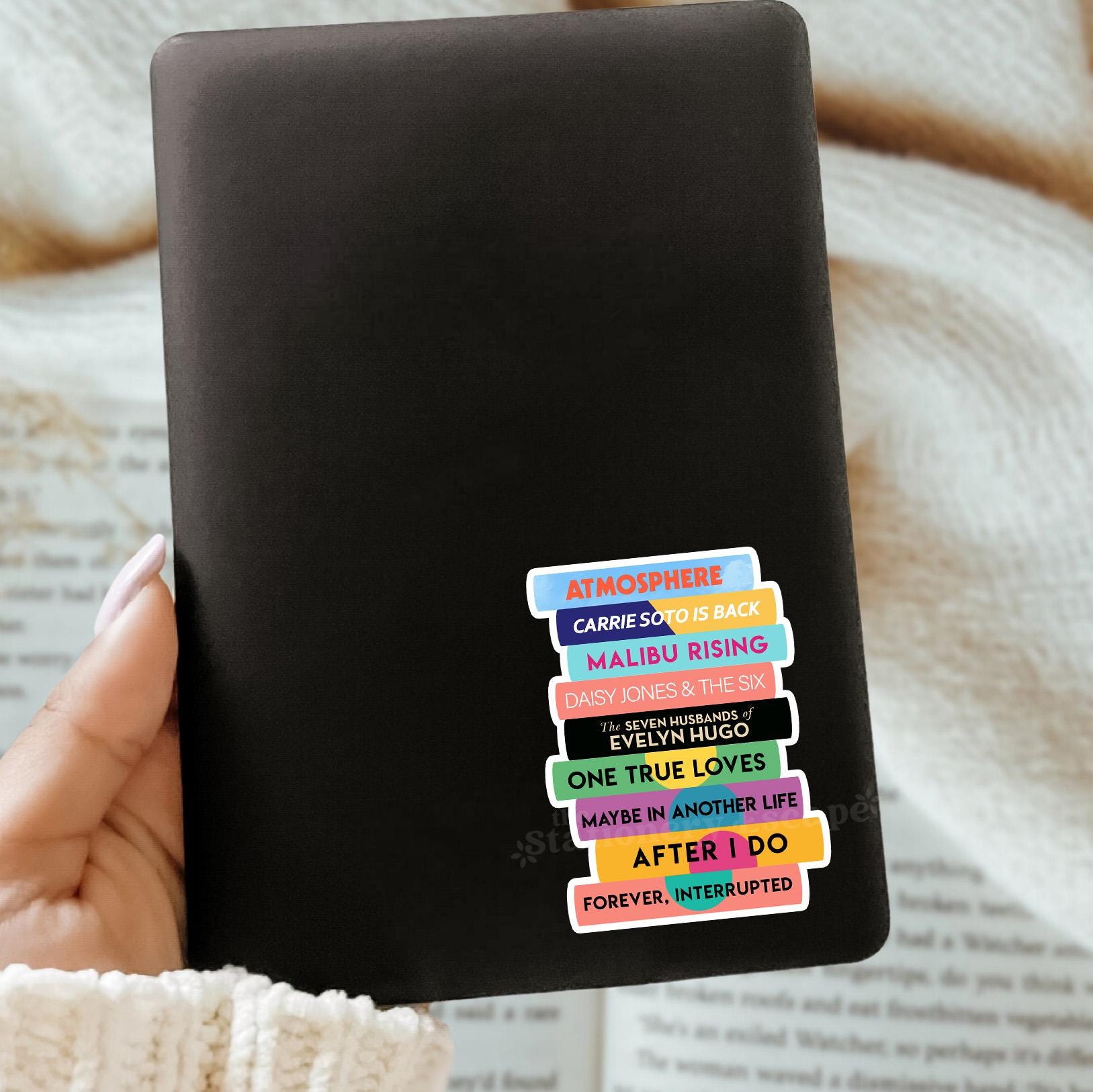 Black Kindle case with colorful Taylor Jenkins Reid book titles stacked on a sticker