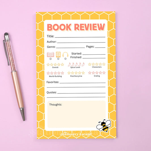Book review notepad with honeycomb design and bee illustration on a pink background