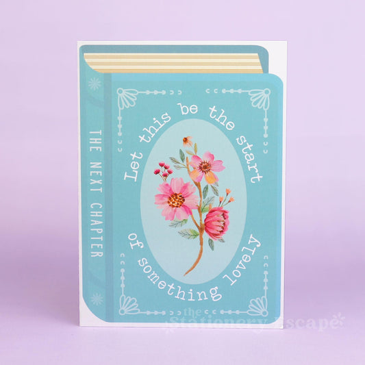 Book-shaped card with floral design and text on a light purple background reading "Let this be the start of something lovely"