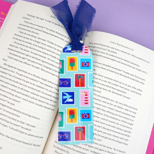 Colorful bookmark with various summer vacation travel stamp icons on an open book