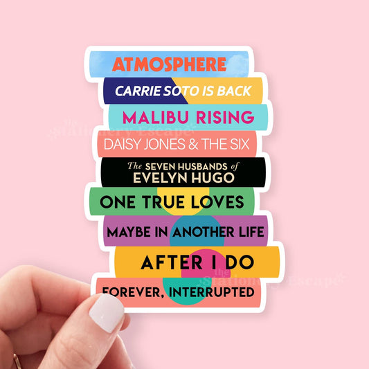 Stack of colorful Taylor Jenkins Reid book title stickers held against a pink background