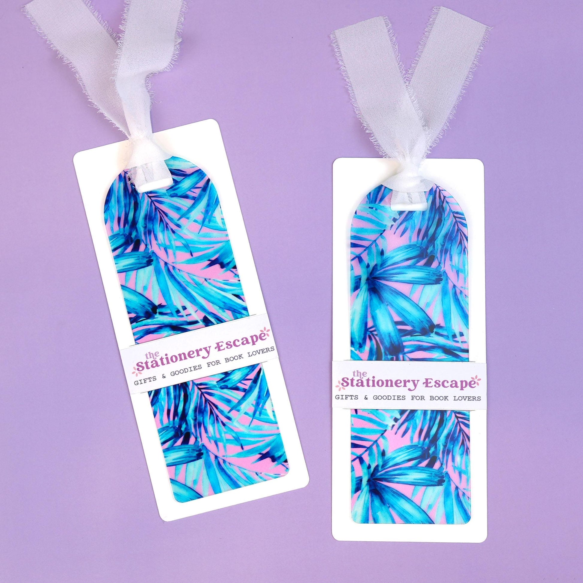 Two colorful bookmarks with a tropical leaf pattern on a purple background, branded 'The Stationery Escape'.