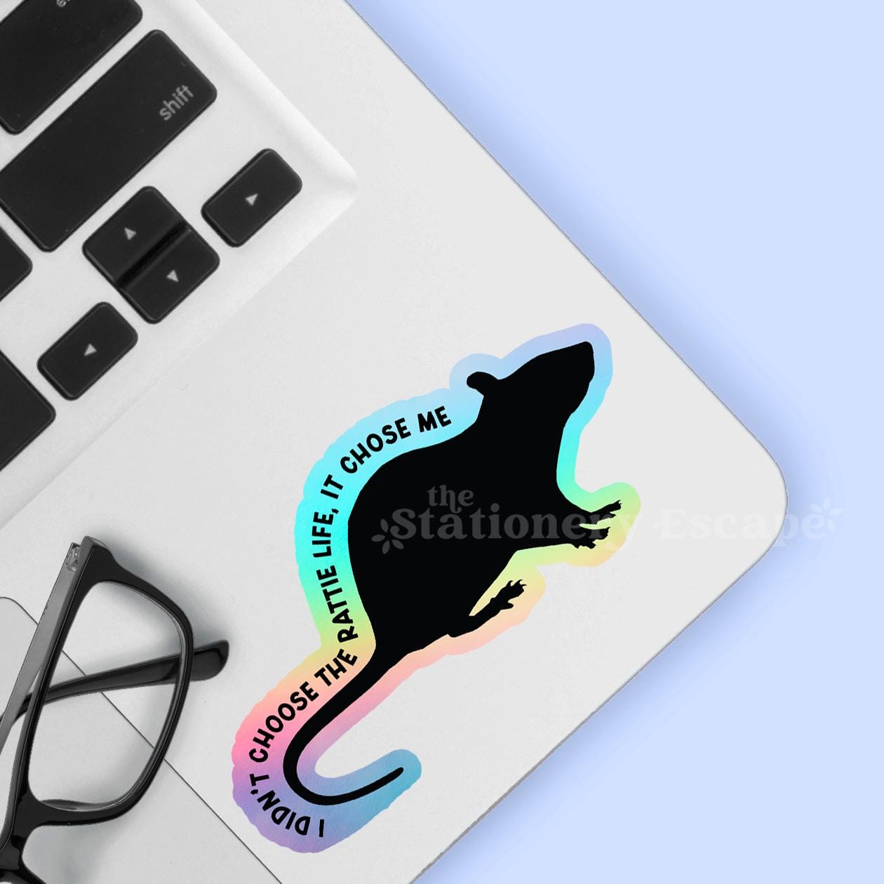 Holographic rat sticker with "I didn't choose the rattie life, it chose me" text on laptop