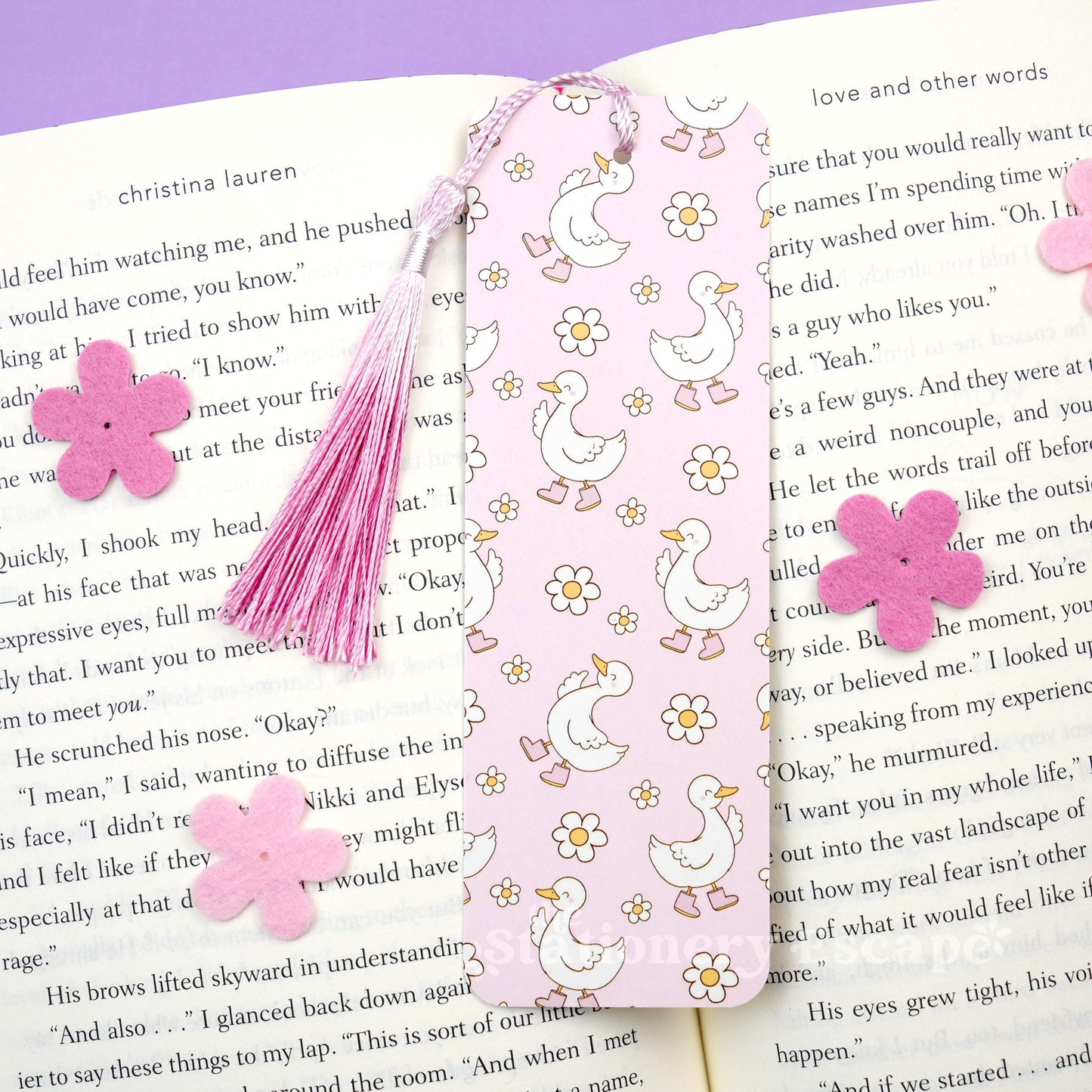 Decorative bookmark with pink tassel and flowers on a book page