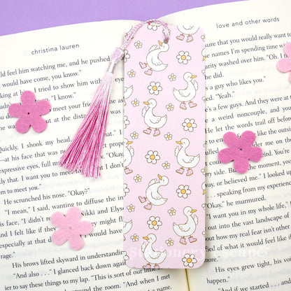 Decorative bookmark with pink tassel and flowers on a book page