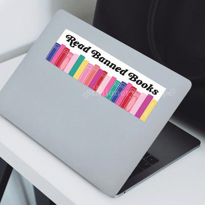 Laptop with a colorful bookshelf bumper sticker design and 'Read Banned Books' text 