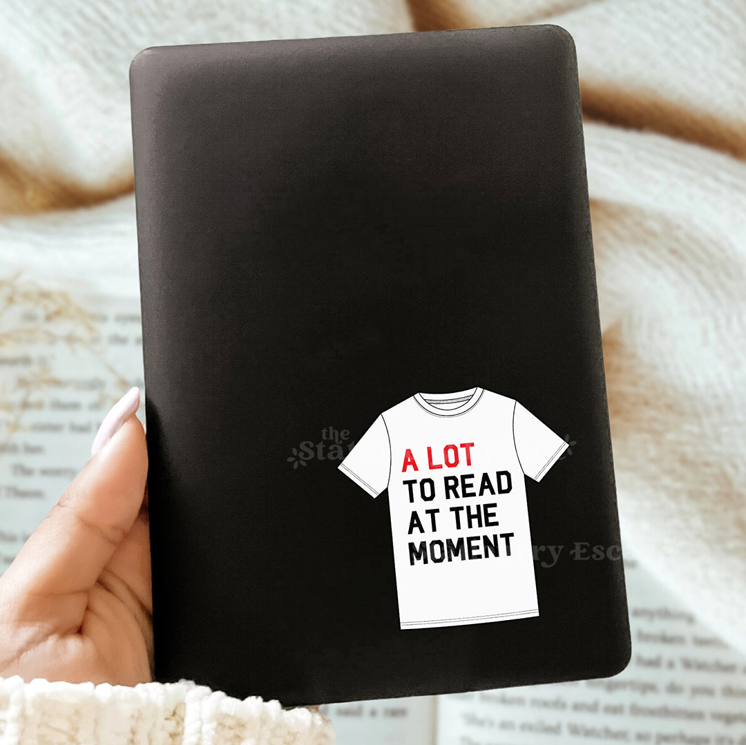 Black notebook with a t-shirt graphic and text on a textured surface
