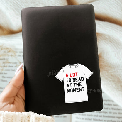 Black notebook with a t-shirt graphic and text on a textured surface