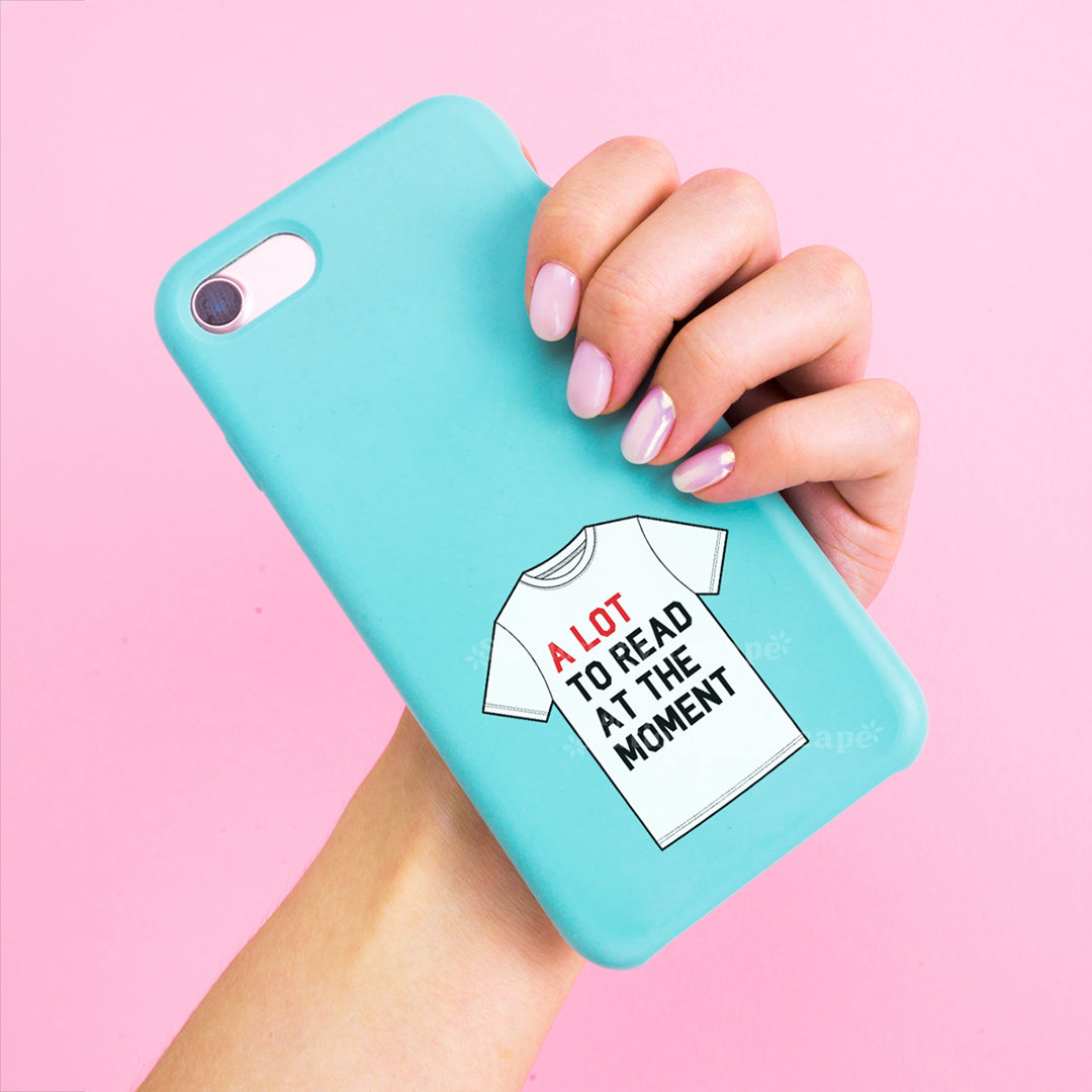 Turquoise phone case with a graphic of a t-shirt and "A Lot to Read at the Moment" text, held by a hand on a pink background