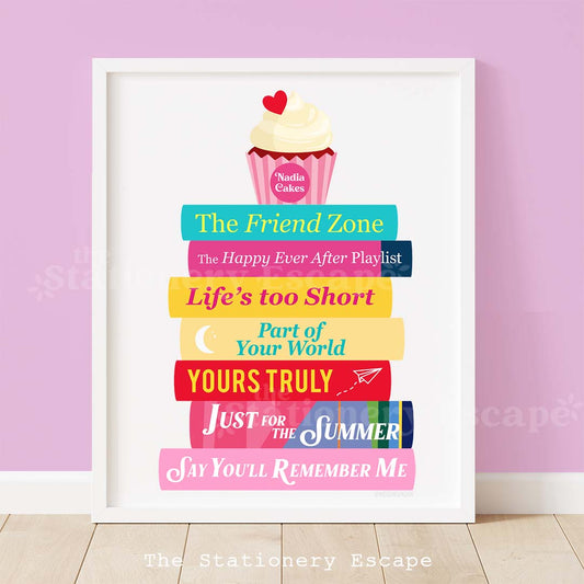 Framed colorful book stack art print with titles featuring romance novel titles by Abby Jimenez. The book stack is topped with a red velvet cupcake.  