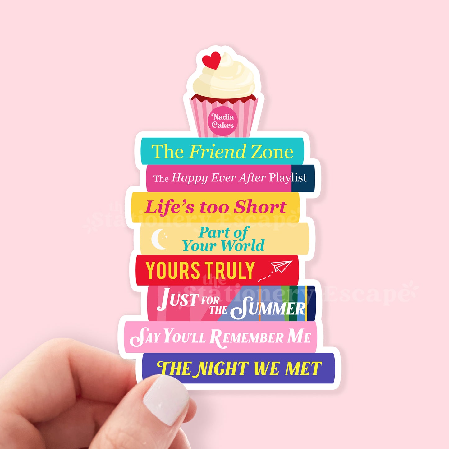 Stack of colorful Abby Jimenez book title stickers with a hand holding them against a pink background