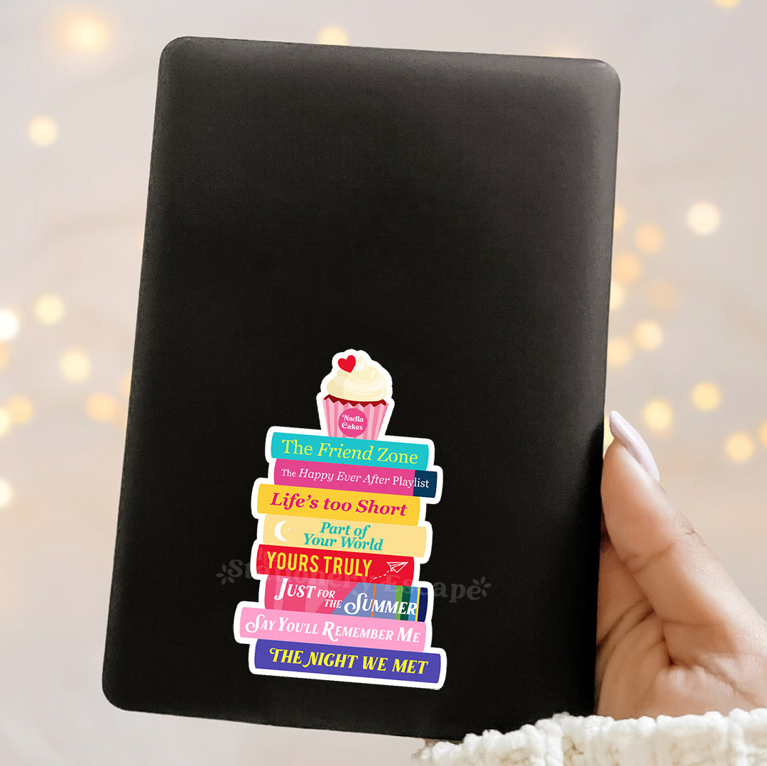 Black Kindle case with colorful Abby Jimenez book stack and cupcake illustration on a blurred light background