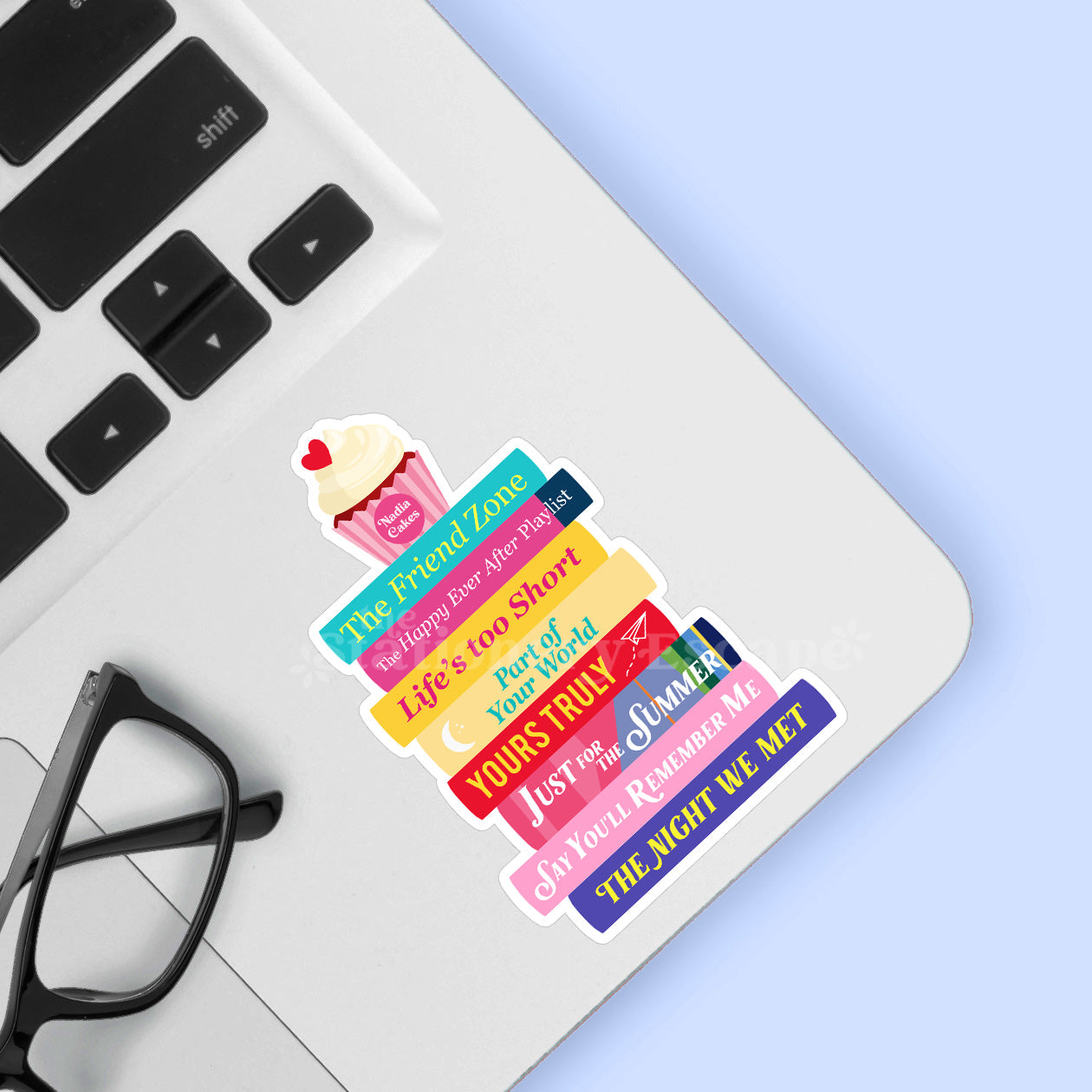 Colorful book stack sticker on a laptop with glasses