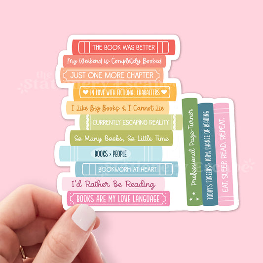 Stack of colorful book-shaped stickers with reading-themed text on a pink background