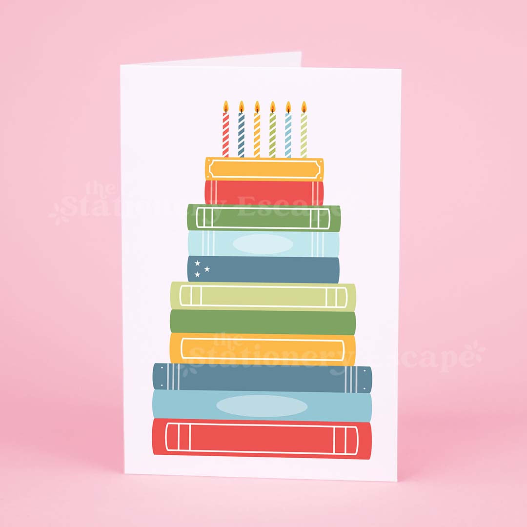Colorful birthday card featuring a "birthday cake" made from brightly colored stacked books 