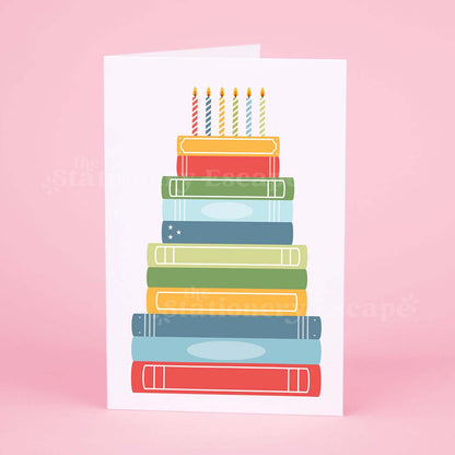 Colorful birthday card featuring a "birthday cake" made from brightly colored stacked books 