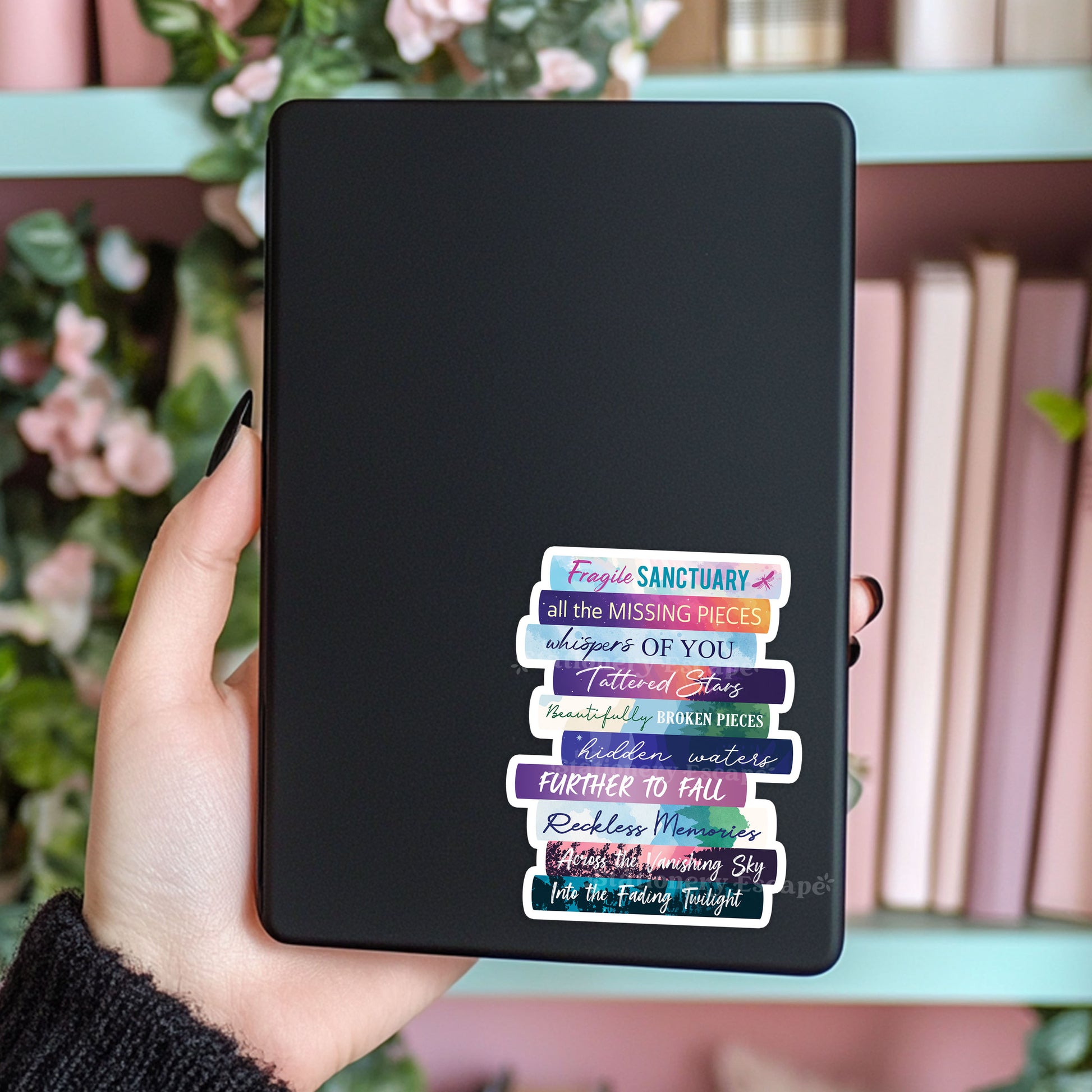 Book Stack sticker on Kindle case featuring the works of Catherine Cowles in colorful book spines with pink books in background