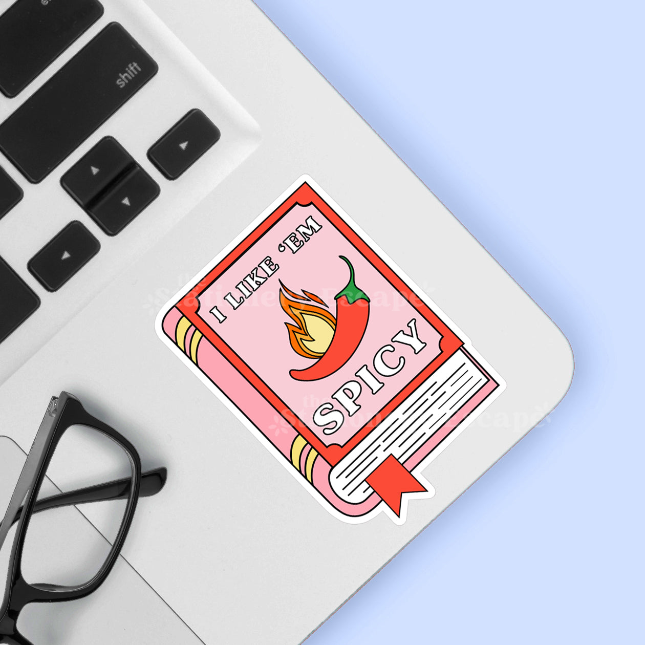 Book sticker with a chili pepper and "I Like 'Em Spicy" text on a laptop