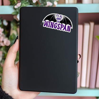 Black Kindle case with 'It's All About The Wingspan' sticker held by a hand.