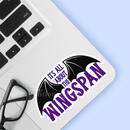 Sticker with 'It's All About the Wingspan' text on a laptop keyboard