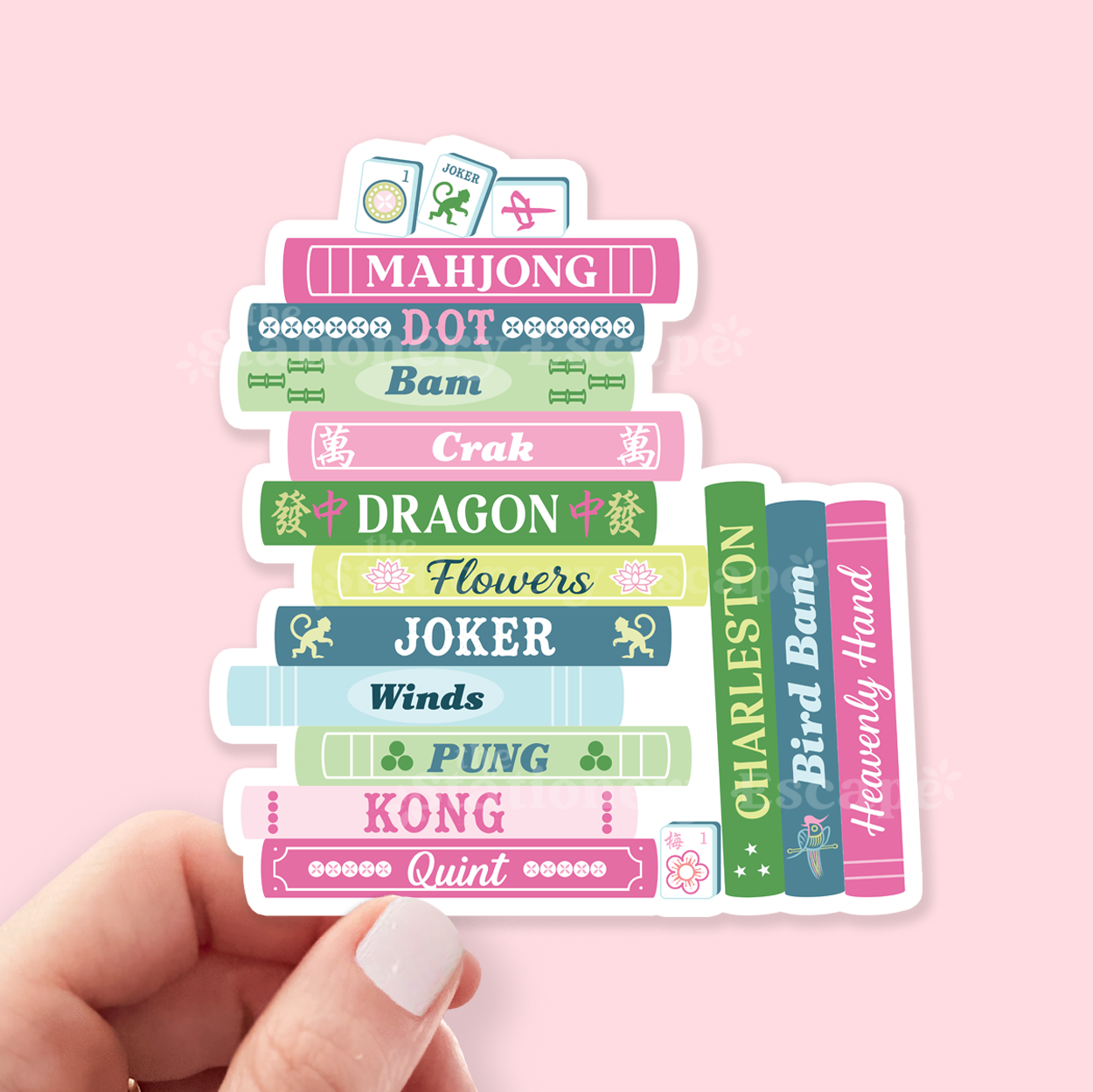 Stack of colorful book-shaped stickers with various mahjong-related words on a pink background