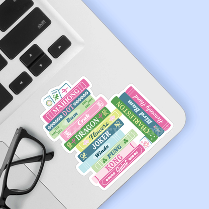 Colorful Mahjong stickers on a laptop keyboard with glasses nearby