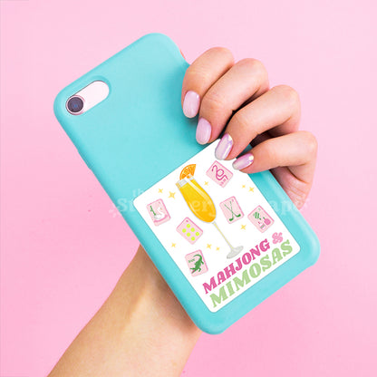 Turquoise phone case with 'Mahjong & Mimosas' design held by a hand on a pink background