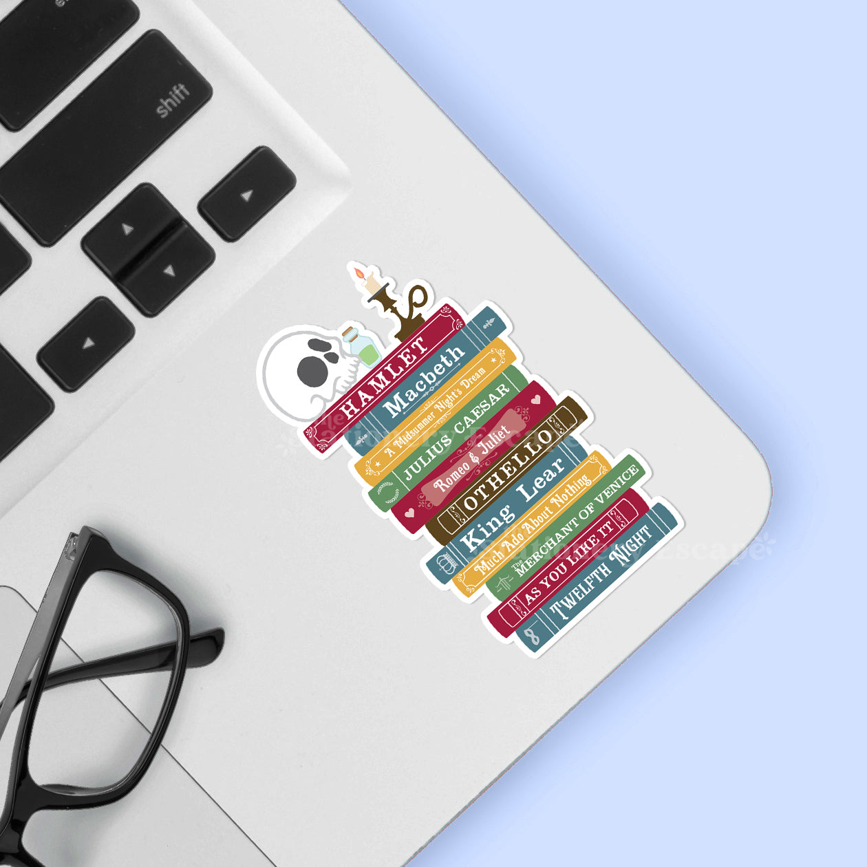 Colorful bookshelf sticker on a laptop with glasses and a light blue background