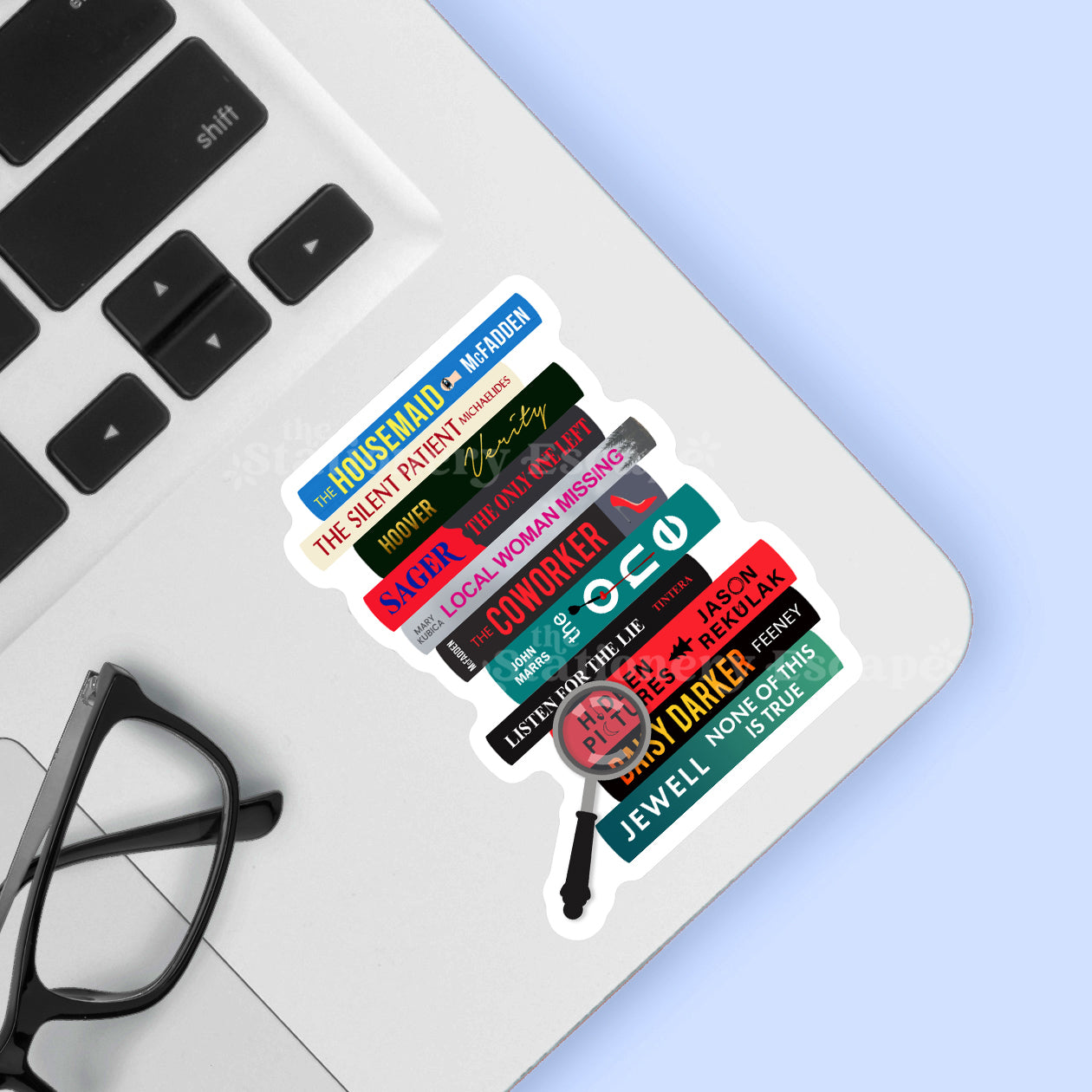 Sticker featuring a stack of thriller books with titles on a laptop keyboard