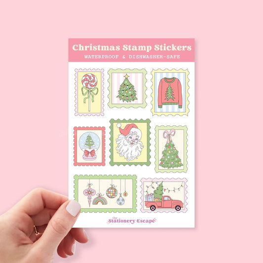 Sheet of Christmas stamp stickers held by a hand on a pink background