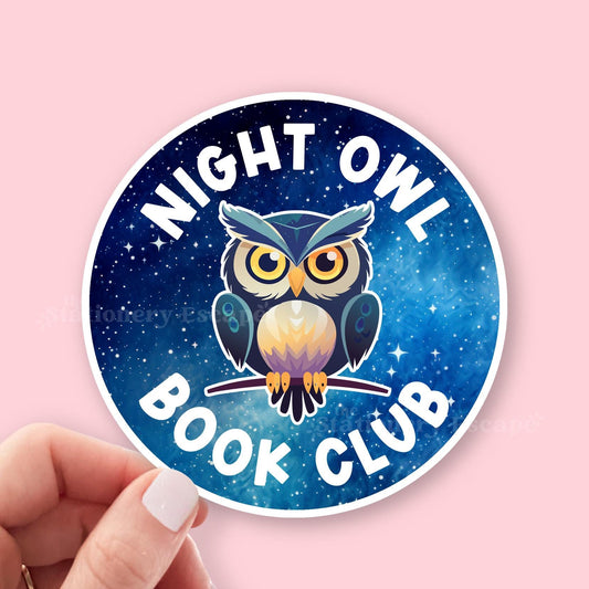 Sticker with an owl design and 'Night Owl Book Club' text on a blue background, held against a pink background.