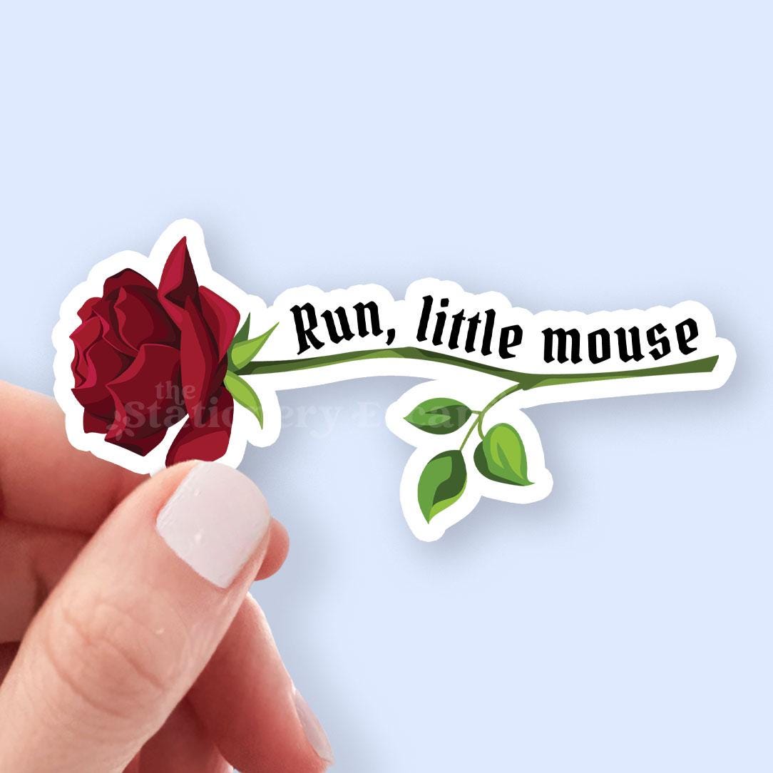 Sticker with a red rose and 'Run, little mouse' text held by a hand against a light blue background.