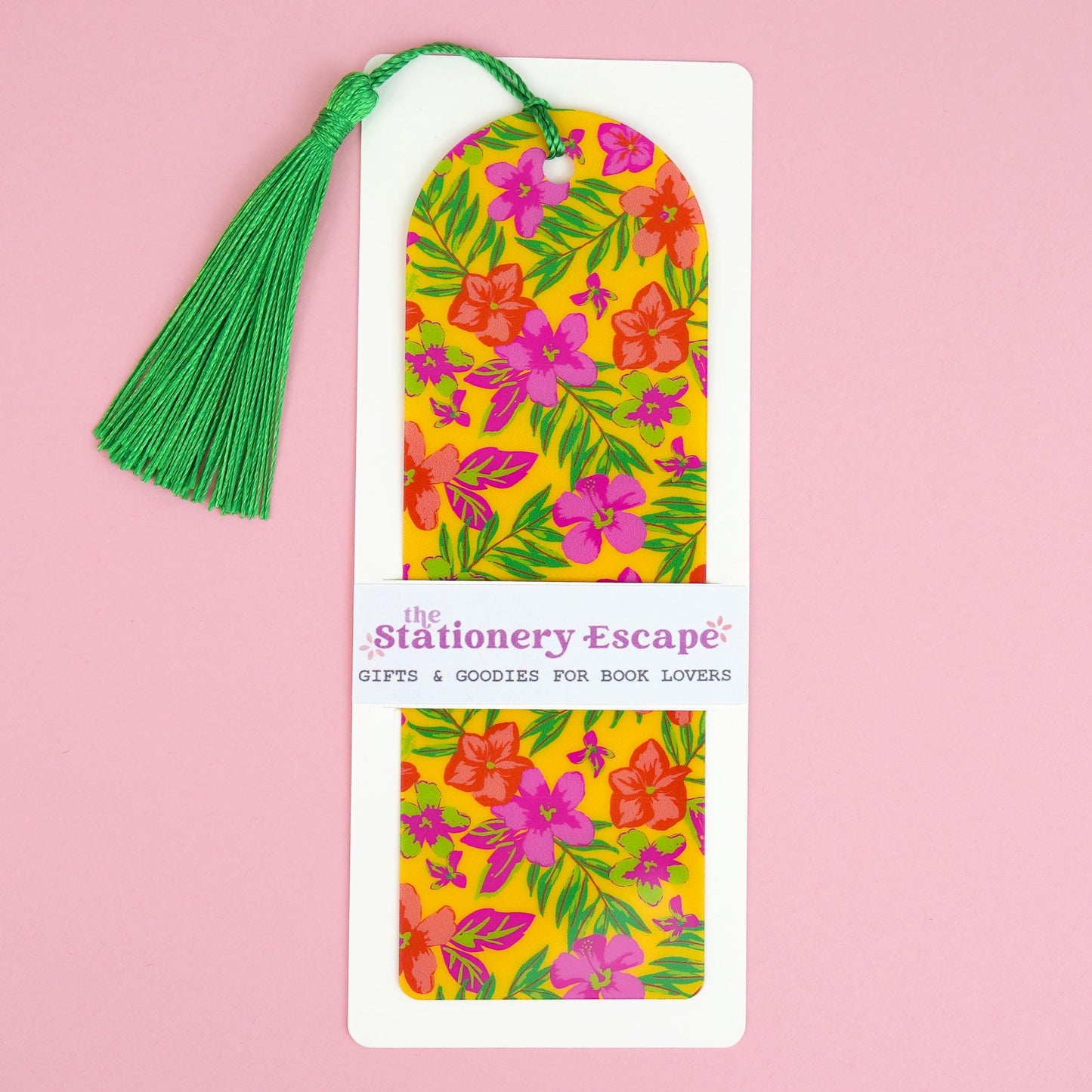 Floral bookmark with green tassel on a pink background, branded 'The Stationery Escape'.
